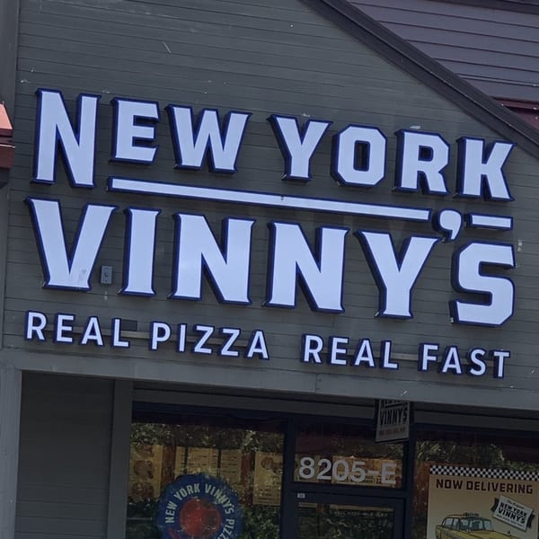 New York Vinny's Pizza restaurant sign with "REAL PIZZA REAL FAST" slogan.